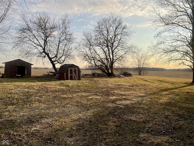 view of yard with a rural view, an outdoor structure, and a shed