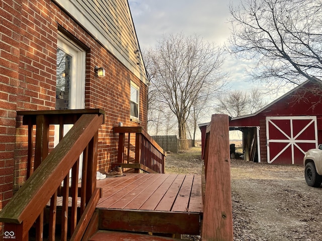 deck with a barn, fence, and an outbuilding