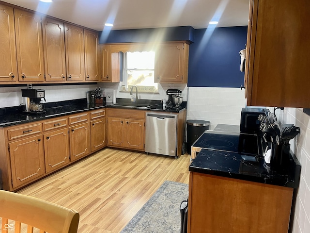 kitchen featuring brown cabinets, tile walls, stainless steel dishwasher, a sink, and light wood-type flooring