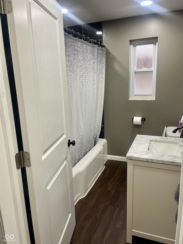 full bathroom with shower / bath combo, baseboards, wood finished floors, and vanity