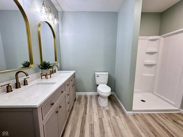 bathroom with toilet, a sink, baseboards, and wood finished floors