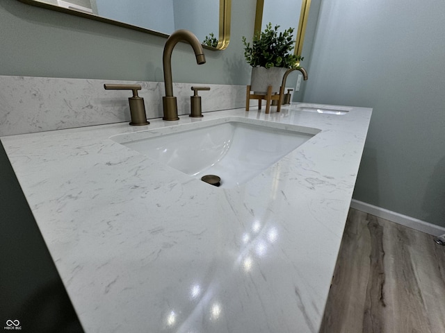 interior details with baseboards, wood finished floors, and vanity