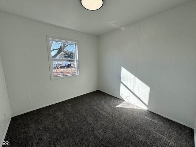 empty room with baseboards and dark carpet