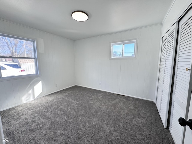 unfurnished bedroom featuring a closet and dark carpet