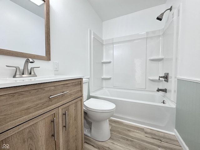 bathroom featuring washtub / shower combination, vanity, toilet, and wood finished floors