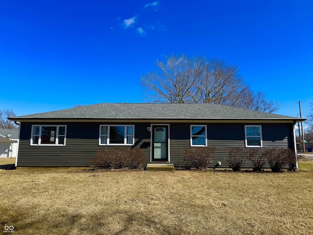 single story home featuring a front lawn and roof with shingles