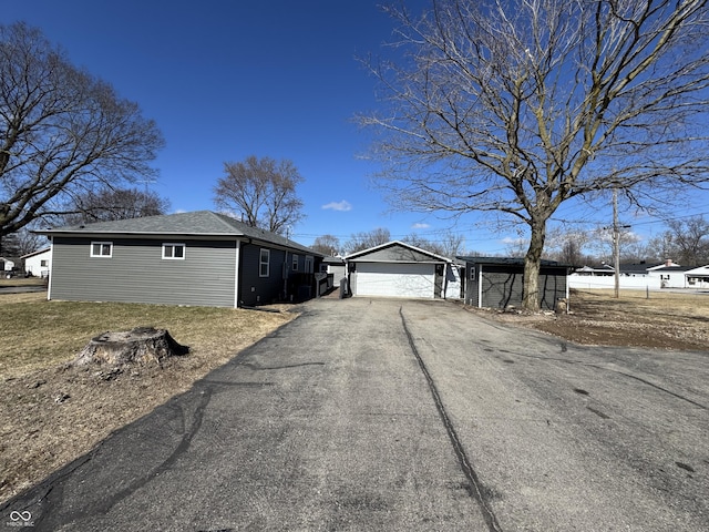 view of front of property featuring an outbuilding, driveway, and a garage