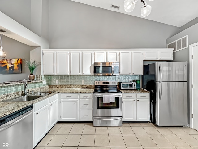 kitchen featuring visible vents, a sink, appliances with stainless steel finishes, white cabinetry, and tasteful backsplash