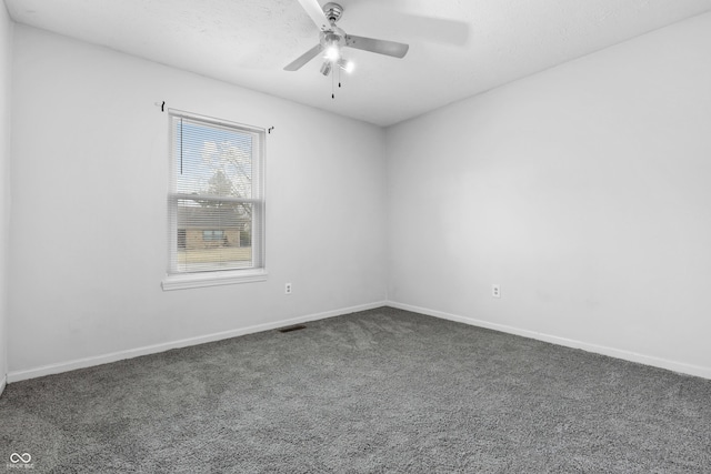 unfurnished room featuring a ceiling fan, dark colored carpet, visible vents, and baseboards