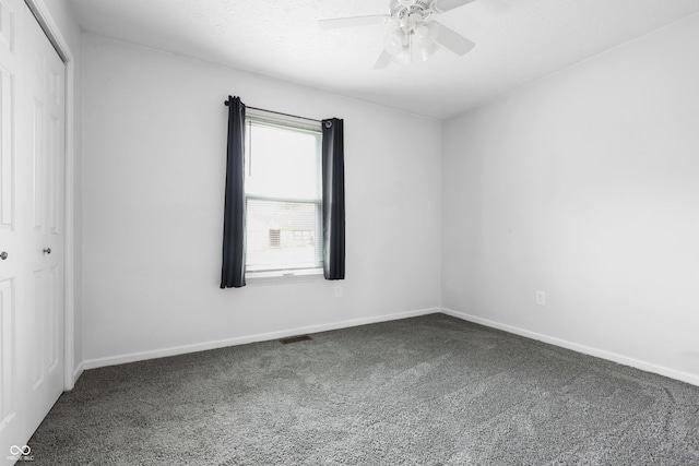 carpeted empty room with ceiling fan, visible vents, and baseboards