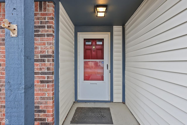 view of exterior entry featuring brick siding