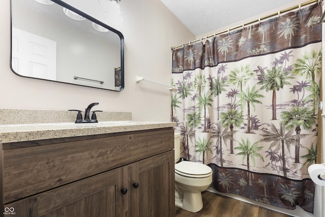 full bathroom with a shower with shower curtain, toilet, vanity, a textured ceiling, and wood finished floors