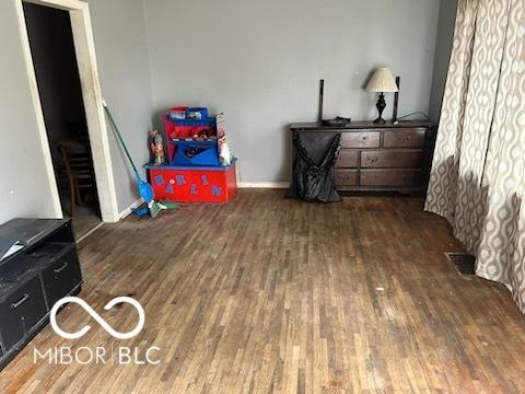 interior space with baseboards, visible vents, and wood finished floors