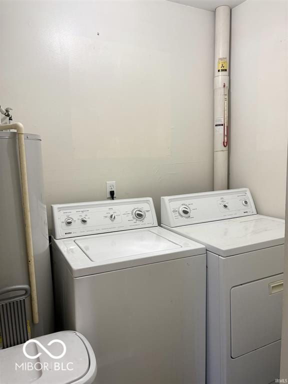 washroom featuring gas water heater, washer and clothes dryer, and laundry area