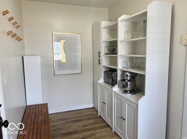 bar with baseboards and wood finished floors