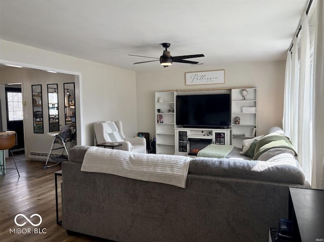 living room featuring dark wood-style floors, ceiling fan, and a baseboard radiator