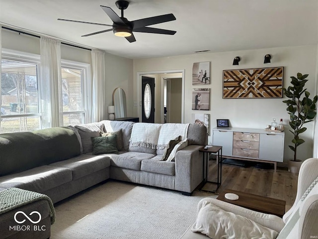 living area with a ceiling fan and wood finished floors