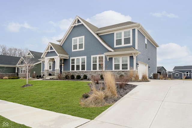 view of front of property with driveway, central AC unit, stone siding, an attached garage, and a front yard