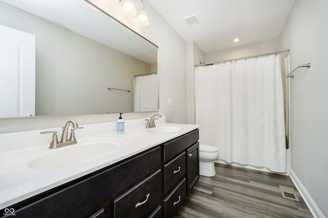 bathroom with visible vents, a sink, and wood finished floors