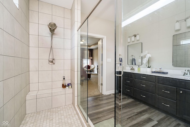 full bathroom with double vanity, a sink, and walk in shower