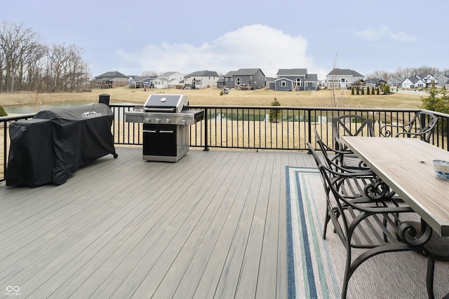 deck featuring a residential view, grilling area, and outdoor dining space