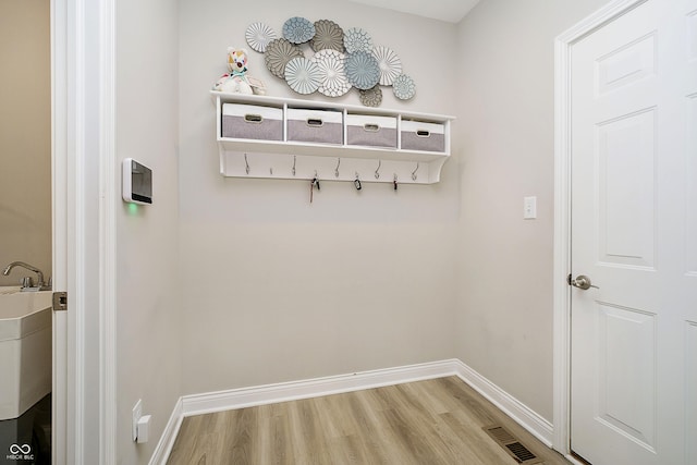 mudroom featuring visible vents, baseboards, and wood finished floors