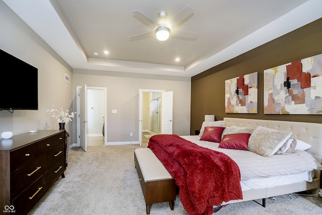 bedroom with a tray ceiling, recessed lighting, visible vents, light carpet, and baseboards