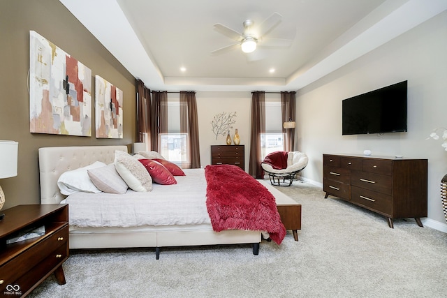 bedroom with baseboards, recessed lighting, a raised ceiling, and light colored carpet