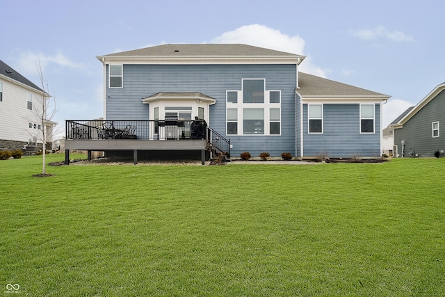 rear view of house featuring a wooden deck and a yard