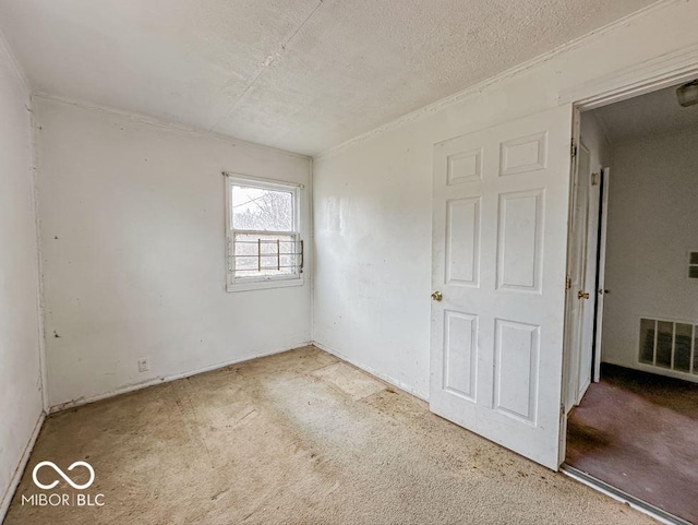 empty room with a textured ceiling and visible vents