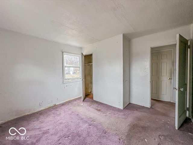 unfurnished bedroom featuring a closet, a textured ceiling, and carpet flooring