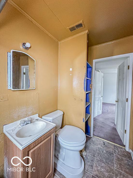 bathroom featuring visible vents, vanity, toilet, and tile patterned floors