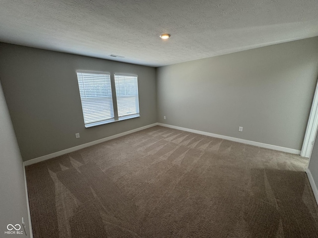 unfurnished room with a textured ceiling, carpet, and baseboards