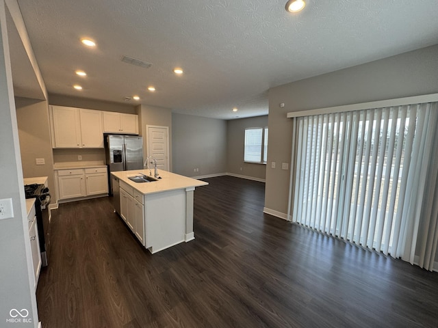 kitchen featuring dark wood-type flooring, open floor plan, light countertops, and a sink