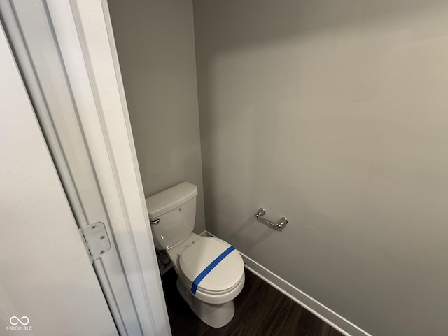 bathroom featuring toilet, baseboards, and wood finished floors