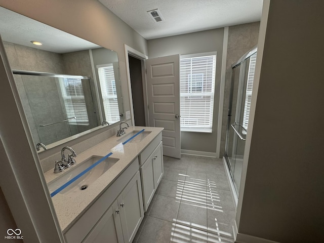 bathroom featuring a stall shower, a sink, and visible vents