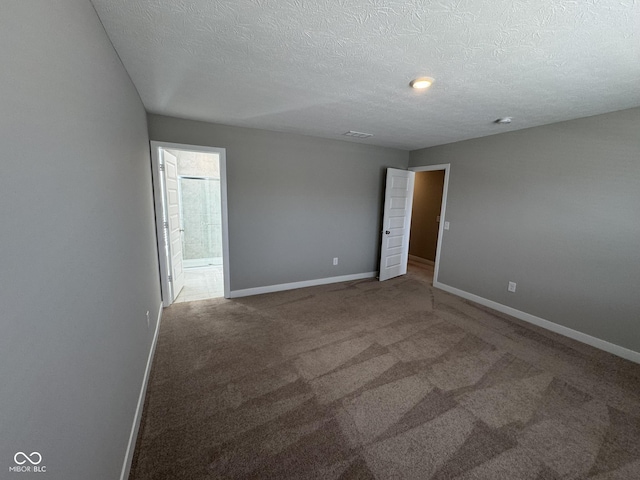 carpeted empty room with a textured ceiling, visible vents, and baseboards