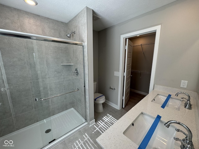 full bath with a sink, toilet, and a shower stall