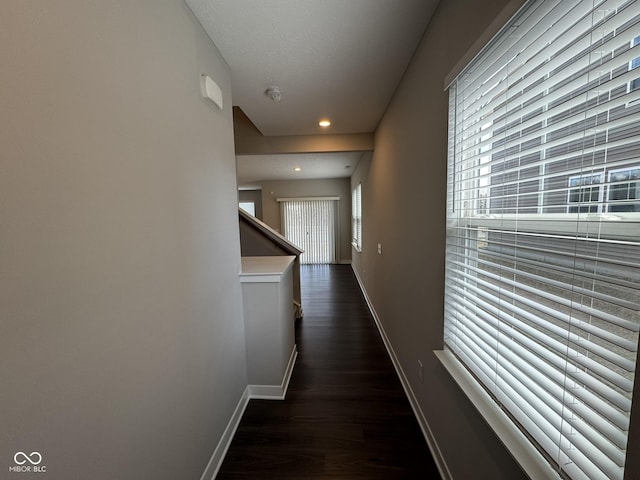 hall featuring recessed lighting, dark wood-style flooring, and baseboards