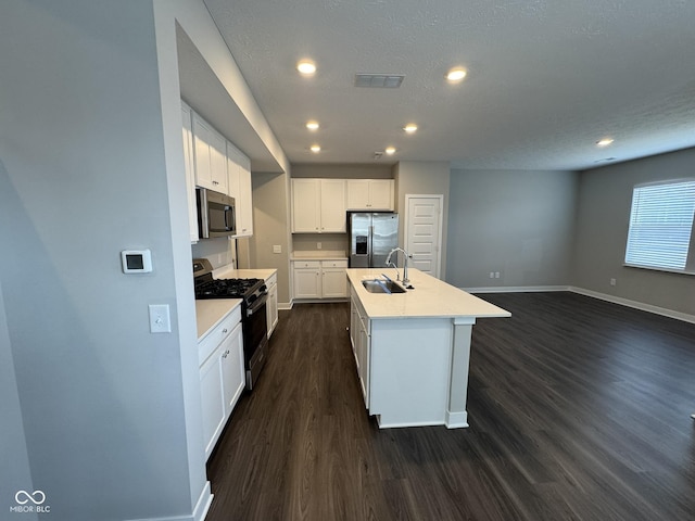 kitchen with baseboards, visible vents, appliances with stainless steel finishes, dark wood-type flooring, and a sink