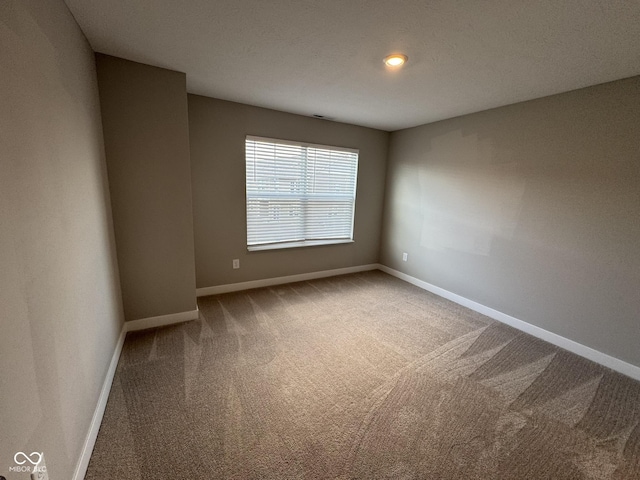 carpeted spare room with baseboards