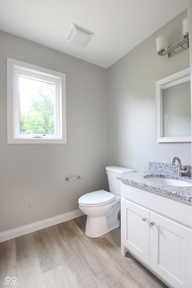 3604 Maple Ridge Dr, Columbus, IN 47201 - half bathroom with wood finished floors, vanity, toilet, and baseboards