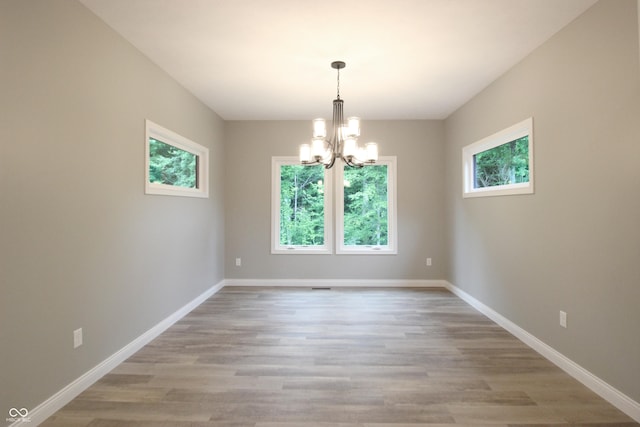 3604 Maple Ridge Dr, Columbus, IN 47201 - spare room featuring a chandelier, light wood-type flooring, and baseboards