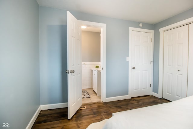 bedroom with a closet, wood finished floors, and baseboards