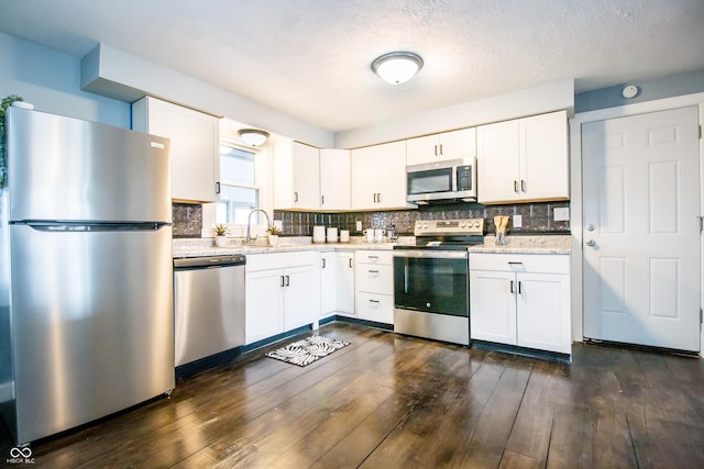 kitchen with white cabinets, tasteful backsplash, stainless steel appliances, and a sink