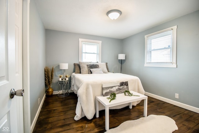 bedroom with dark wood finished floors and baseboards