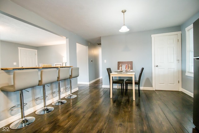 dining space with visible vents, baseboards, and hardwood / wood-style floors