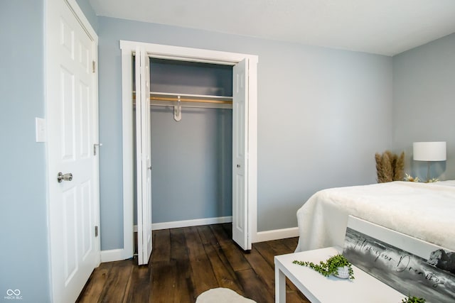 bedroom featuring a closet, dark wood finished floors, and baseboards