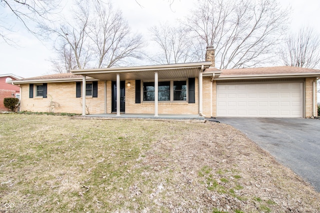 ranch-style house with aphalt driveway, a chimney, an attached garage, and brick siding