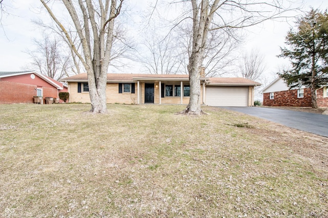 ranch-style house featuring a garage, a front yard, brick siding, and driveway